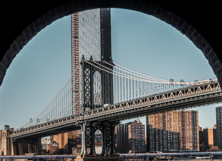 The Brooklyn Bridge as seen under an archway.