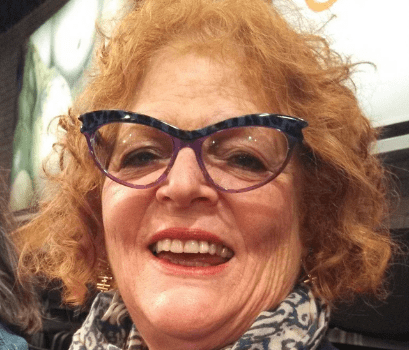 A portrait of Susan Birnbaum with her trademark red hair.