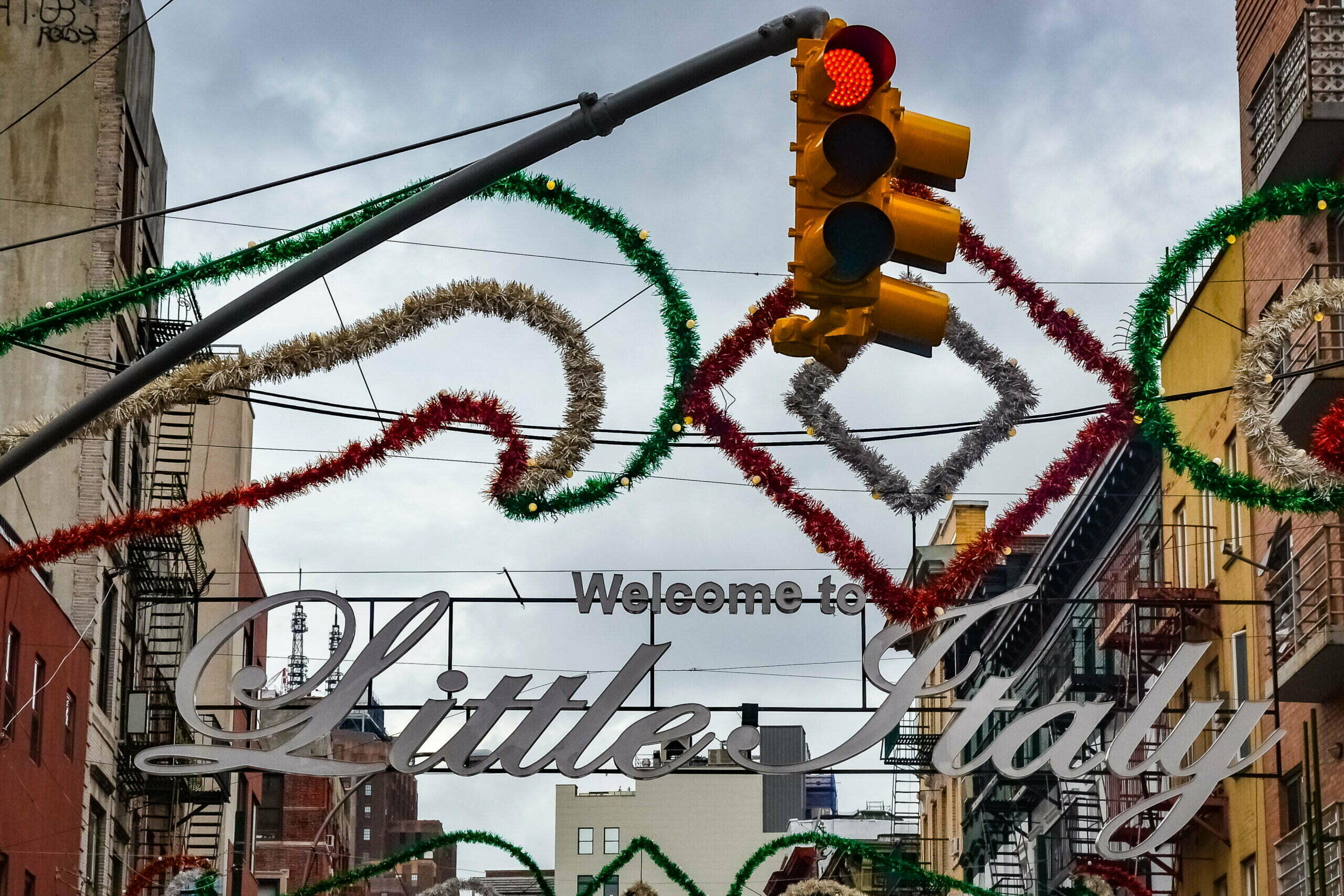 The entrance of little Italy, stoplight with Christmas garlands in the background.